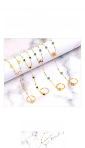 Detail of titanium steel gold hand chains featuring heart and clover pendants