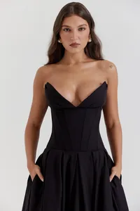 Detail view of structured V-neck bodice with boning on a black mid-length dress