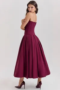 Detail of burgundy corset-style bodice with fine stitching and voluminous midi skirt