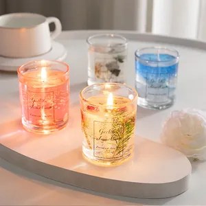 Macro view of jelly scented candles with dried flowers and gold foil in clear glass