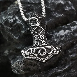 Close-up of vintage Viking Mjolnir pendant with Celtic knots on dark textured stone