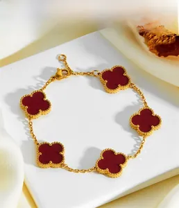 Exquisite gold bracelet with five red carnelian clover charms and elegant beaded edges