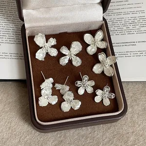 French vintage shell flower stud earrings set with pearls on a dark velvet jewelry box