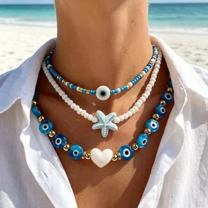 Detailed shot of layered beach beaded necklaces with evil eye and starfish pendants