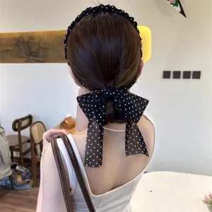 Detailed back view of a retro polka dot headband with a large elegant ribbon bow