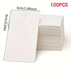 Detailed macro view of 100 white earring display cards with 5x9cm measurements label