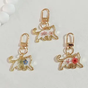 Cat-shaped resin keychains with real dried flowers in gold-tone metal frames