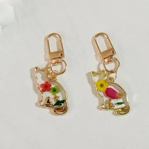 Handmade cat-shaped resin keychain featuring colorful dried flowers and a gold metal clip
