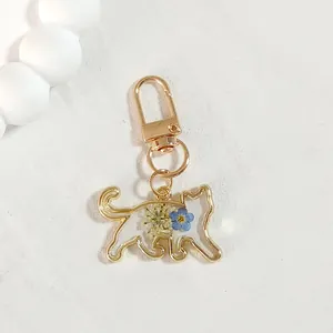 Exquisite detail view of a handmade cat keychain with real dried flowers in clear resin