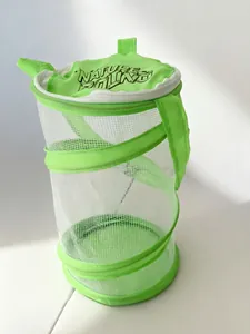 Detailed view of a foldable green mesh insect cage with a nature-themed top cover