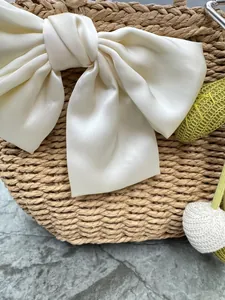 Exquisite hand-woven straw vacation handbag decorated with a large cream silk bow