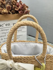 Detailed view of hand-woven straw holiday bag featuring white ribbon and lining