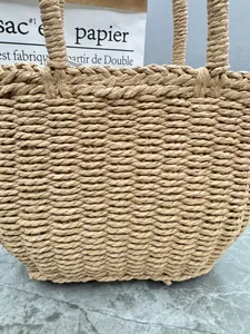 Close-up detail showing the intricate hand-woven straw texture of the vacation tote bag.