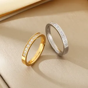 Close-up detail of minimalist gold and silver stainless steel rings with embedded zircon