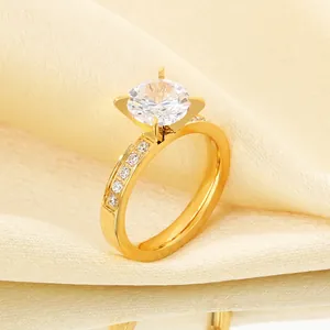 Detail of a gold stainless steel ring featuring a four-claw set zircon center stone