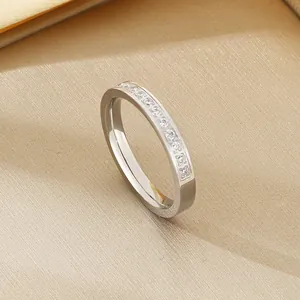 Macro detail of a silver stainless steel ring featuring a row of sparkling white zircons.