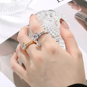 Elegant silver and gold stainless steel rings with four-prong zircon setting on hand