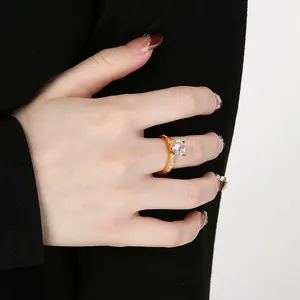 Detailed macro shot of a golden stainless steel ring featuring a four-prong set zircon