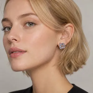 Detail shot of elegant geometric cross earrings with red enamel and crystals on a model