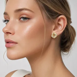 Elegant gold-plated knot stud earrings with pink enamel and crystals on a model.