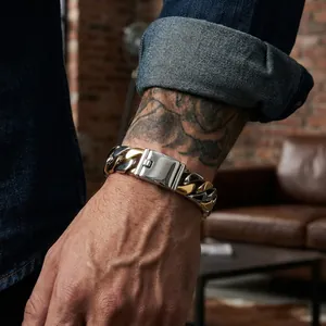 Detailed view of the bicolor titanium steel Cuban chain bracelet on a tattooed wrist