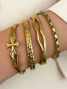 Exquisite set of four gold stainless steel bangles including cross and blue stone details