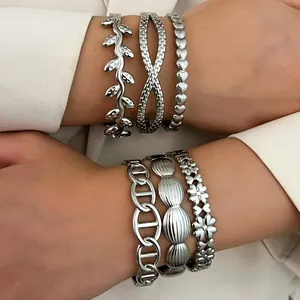Close-up of various silver stainless steel bracelets with leaf and flower motifs for women
