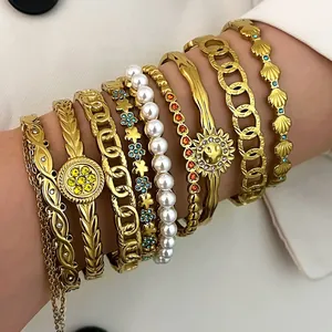 Close-up of elegant gold-plated stainless steel bracelets with pearls and sun motif
