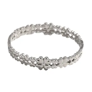 Detailed view of hollow-out heart and clover pattern on silver stainless steel bangle
