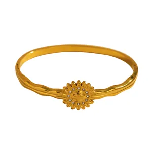 Detailed view of a gold flower bangle bracelet featuring small crystal stone accents