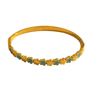 Detailed view of elegant gold stainless steel flower bangle with blue rhinestone inlay for women