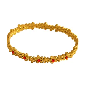 High-quality detailed shot of a gold-plated stainless steel flower bangle with red stones