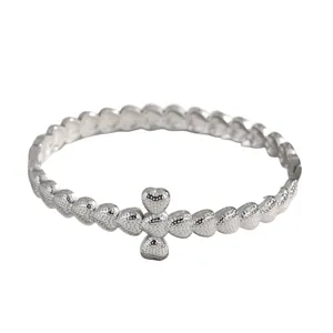 Detailed view of a silver stainless steel bracelet featuring textured heart charms.