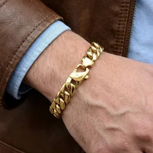 Détail d'un bracelet gourmette en acier inoxydable doré pour homme au poignet.