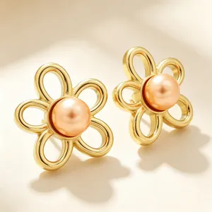 Close-up detail of vintage French style gold flower stud earrings with peach pearl
