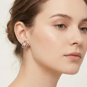 Close-up shot of French vintage flower earrings with pearl inlay on a female model