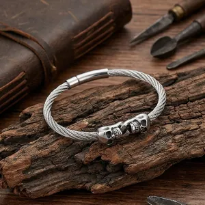 Detailed view of gothic double skull titanium steel wire bracelet on rustic wood