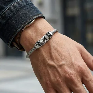 Close-up of a masculine gothic double skull stainless steel wire bracelet on a man's wrist