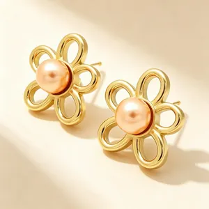 Vue rapprochée détaillée des boucles d'oreilles fleur en or 18K et perle pêche centrale