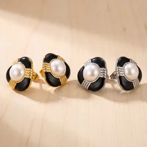Vue détaillée de boucles d'oreilles perles en émail aux finitions or et argent.