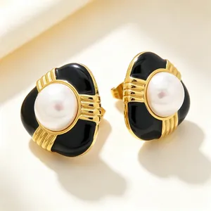 Détail de boucles d'oreilles vintage en émail noir et perles de nacre avec finition dorée