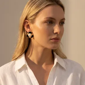 Gros plan détaillé d'une boucle d'oreille minimaliste en émail noir avec une perle