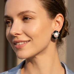 Gros plan d'une élégante boucle d'oreille en émail noir avec une perle de nacre