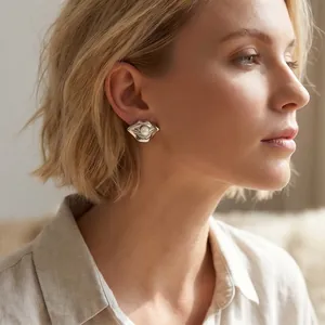 Primo piano di modella con orecchini creativi in argento a forma di labbra e perla