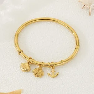 Elegant 18k gold plated stainless steel bangle with seashell fish and anchor charms