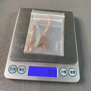 Detailed view of gold-toned stainless steel envelope pendant necklace weighing 8.8 grams