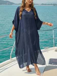 Elegant navy blue V-neck loose beach cover-up long kaftan dress shown on a yacht deck