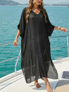 Elegant woman wearing black V-neck split beach cover-up dress on a luxury yacht