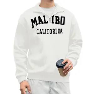 Close-up of men's white vintage half-zip sweatshirt with Malibu text print detail.