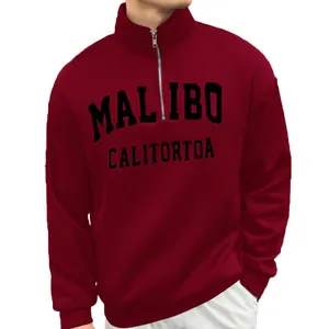 Close-up view of the half-zip collar and chest graphic on a burgundy men's sweatshirt